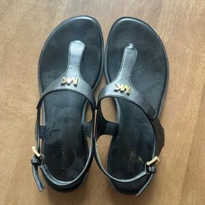 Micheal Kors black sandals with gold accessories.